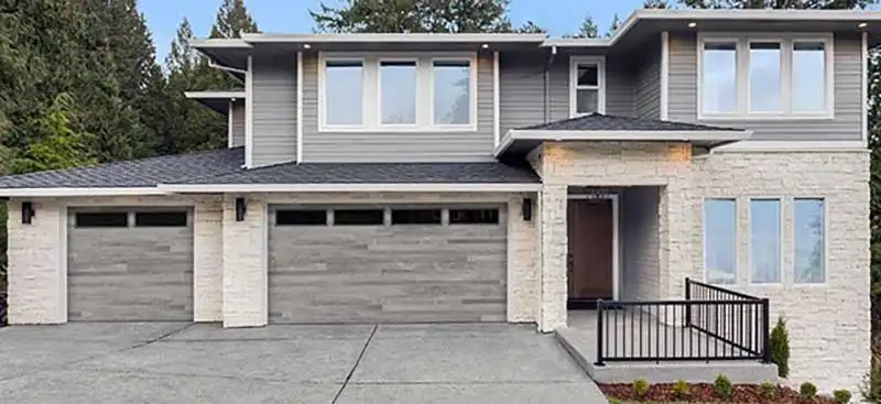 Gray two story home with two modern garage doors