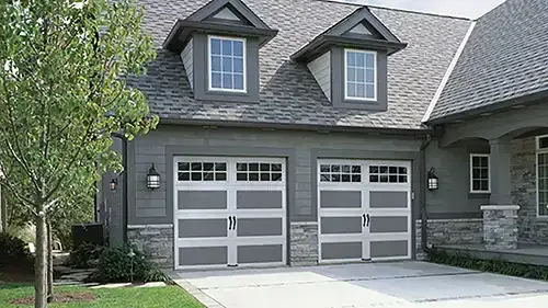 Two carriage style garage doors on a gray stone home