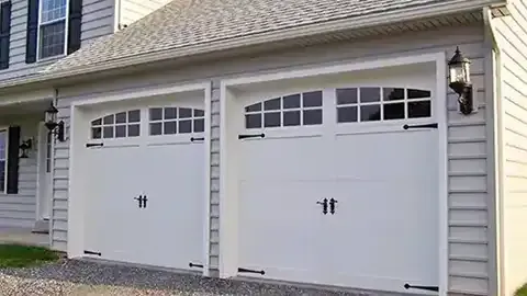 Two white carriage style garage doors with arched windows